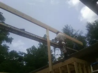 Carpenter setting a ridge beam over a new addition frame — Ice Dam Removal by Roofing Brothers in Mentor